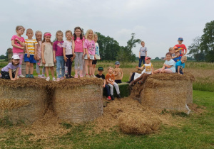 Dzieci z grupy ,,Żabki" pozują do zdjęcia na stogach siana