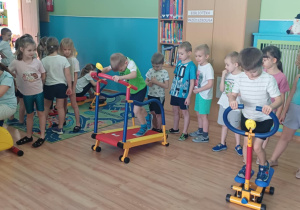 Zdjęcie przedstawia grupę dzieci, które korzystają ze sprzętu na siłowni