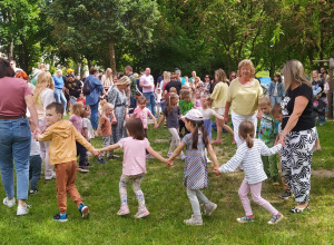 Zdjęcie przedstawia dzieci i rodziców podczas pikniku