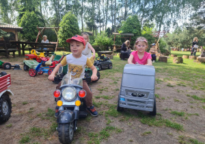 Natalia jeździ na zabawkowym motorze a Pola na ciężarówce