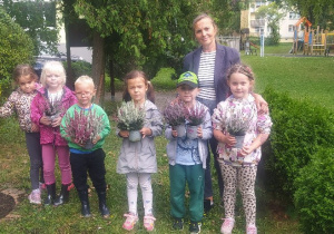 Zdjęcie przedstawia dzieci z wrzosami