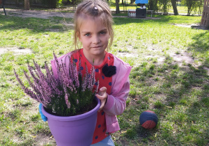 Zdjęcie przedstawia dziewczynkę z pięknym wrzosem