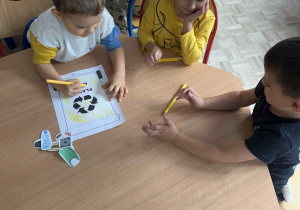 Makar, Janek i Maksym kolorują pojemnik