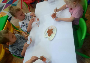 Dzieci malują kubeczki na brązowo