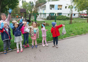 Zdjęcie przedstawia dzieci, które zbierają śmieci