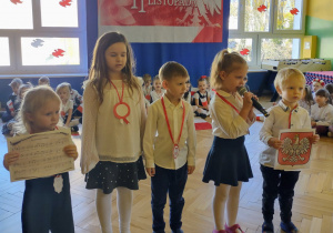 Zdjęcie przedstawia dzieci recytujące wiersze o symbolach narodowych