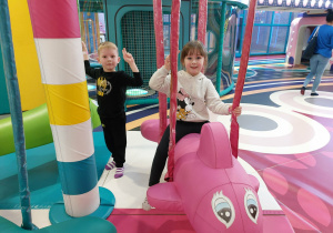 Zdjęcie przedstawia dziewczynkę na karuzeli