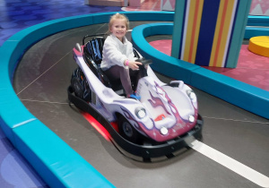 Zdjęcie przedstawia dziewczynkę podczas jazdy w aucie