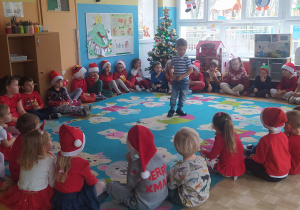 Zdjęcie przedstawia chłopca, który zadaje zagadkę dzieciom