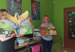 Zdjęcie przedstawia panią bibliotekarkę, która pokazuje książkę