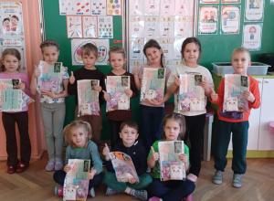 Dzieci pozują do zdjęcia z podziękowaniami