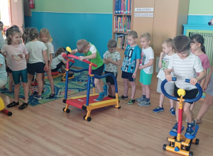 Grupa żabek wykonuje ćwiczenia na mini siłowni