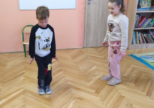 Zdjęcie przedstawia chłopca naśladującego poruszanie się pingwina