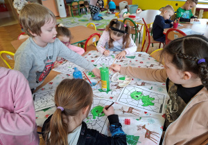 Zdjęcie przedstawia dzieci podczas malowania farbami