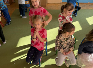 zdjecie przedstawia dzieci bawiace sie we fryzjera