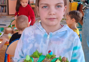 Zdjęcie przedstawia dziewczynkę i jej stroik