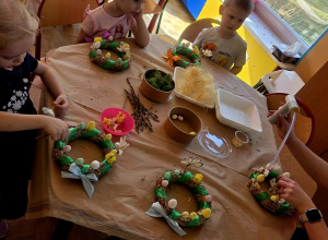 zdjecie przedstawia dzieci przy stroikach wielkanocnych