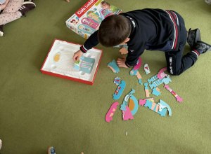 zdjecie przedstawia dziecko ukladajace puzzle
